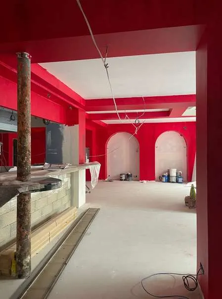 Chantier : arches rouges et comptoir en cours de pose