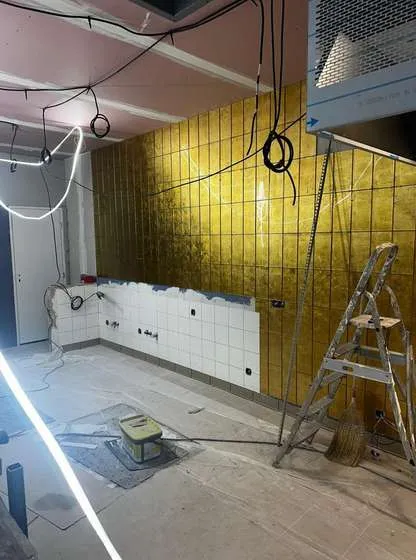 Chantier : mur de zellige doré en cours de pose