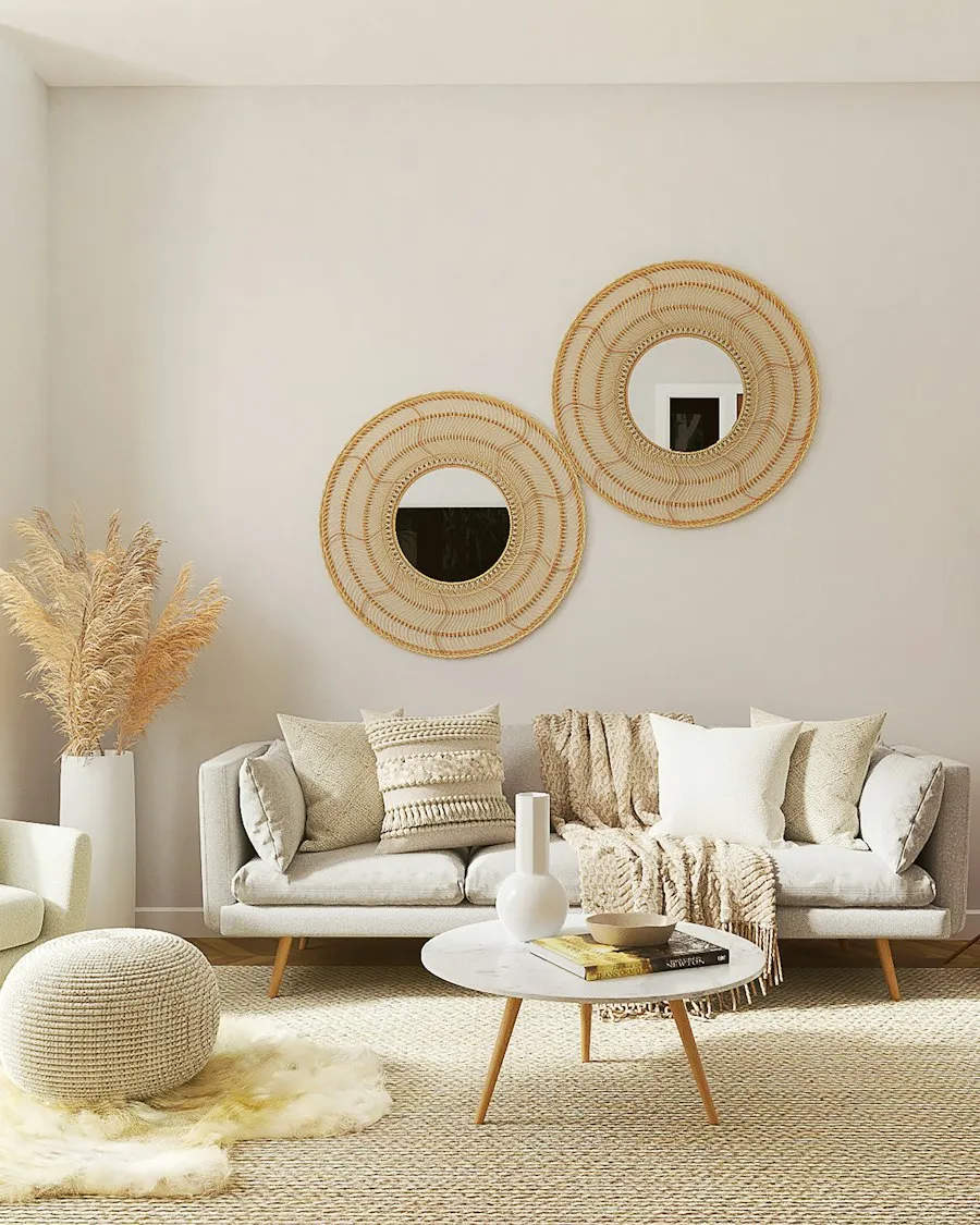Salon aux tons naturels : miroirs en rotin, canapé lin et tapis de jute