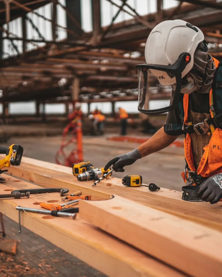 Artisan découpant des poutres en bois sur un chantier